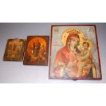 A Russian religious icon, being a polychrome painted panel, 31 x 26cm; and two other smaller