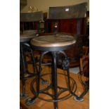 A set of four industrial black painted wrought iron and stained pine bar back revolving machinist