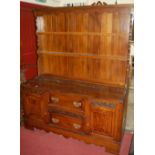 A 1930s relief carved oak dresser, having two-tier open plate rack over base fitted with twin