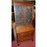 An Edwardian mahogany and satinwood crossbanded bureau bookcase, having twin astragal glazed upper