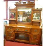 A late Victorian relief carved oak mirrorback sideboard, having three bevelled mirrorplates over