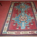 A Caucasian burgundy ground woollen rug, having stepped floral geometric central field within