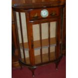 A 1930s chinoiserie lacquered single door china display cabinet, with Smiths 30 hour inset clock,