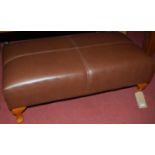 A contemporary Multiyork tan leather long footstool raised on squat cabriole supports, width 93cm