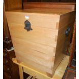 A contemporary Multiyork beech hinged top storage chest, having iron end carry handles, w.54cm;