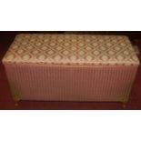 A Lloyd Loom pink painted wicker and upholstered hinge top blanket box, together with a further