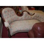 A mid-Victorian mahogany framed show framed chaise longue, having floral buttoned upholstery on