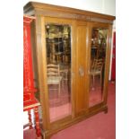 An Edwardian oak twin mirror door wardrobe (plinth requires restoration), w.166cm