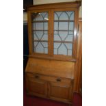 An Edwardian oak bureau bookcase having twin lead astragal glazed upper doors, width 123cm