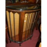 A 1930s mahogany ledgeback demi-lune single door china display cabinet, having a gadrooned edge,