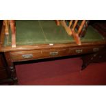 A late Victorian walnut and gilt tooled green leather inset two drawer writing table, on ring turned