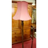 A turned walnut standard lamp, having a reeded column; together with a further turned standard