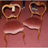 A pair of Victorian walnut balloon back salon chairs