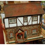 A hand made Tudor style dolls house titled "Ivy Cottage", with sliding front and dolls house