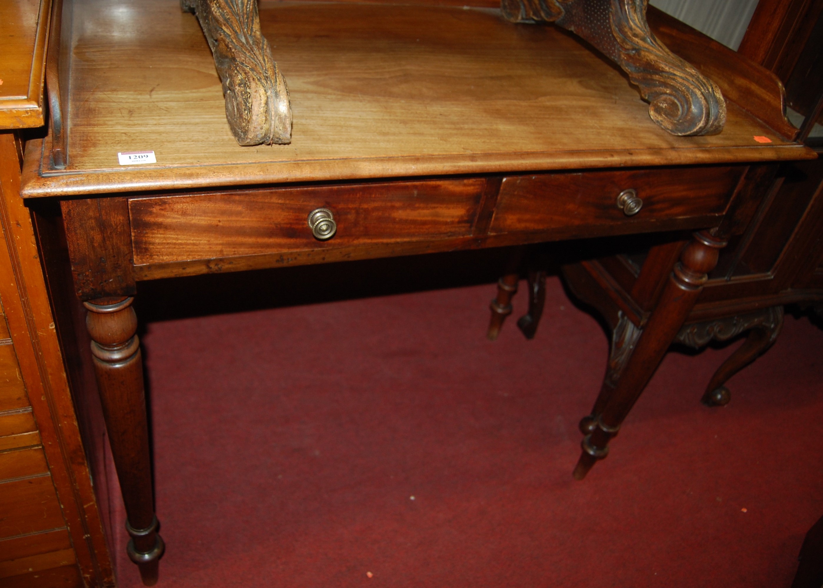 A 19th century mahogany three-quarter gallery backed two drawer side table on turned supports, w.