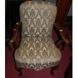 An early 20th century walnut framed and floral upholstered open armchair in the Georgian taste