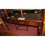 A Victorian style mahogany round cornered gilt tooled leather inset library table, having three