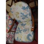 An Ercol mid elm stickback open armchair having floral upholstered cushions