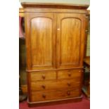 A mid-Victorian mahogany round cornered linenpress, having twin arched panelled upper doors