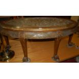 An Indonesian relief carved camphorwood oval coffee table, width 130cm