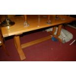 A contemporary light elm joined and planked top refectory table, having cleated ends and raised on