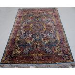 A Persian woven silk Tabriz type rug, having a central flowerhead issuing further scroll flowers and