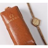 A lady's mid 20th century 9ct gold Omega wristwatch, the cream coloured dial with Arabic numerals,