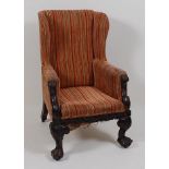 A Victorian walnut framed wing armchair, the whole re-upholstered in a striped velour, having scroll