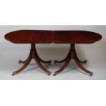 A 19th century mahogany twin pedestal dining table, having D-ends and raised on four outswept reeded