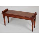 A Victorian style mahogany window seat, having a rectangular top with rolled ends, raised on