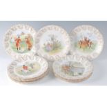 A set of twelve Edwardian Collingwood porcelain dessert plates, each hand-decorated with scenes from