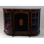 A Victorian walnut and ebonised credenza, having twin glazed bowed end doors enclosing shelved