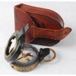 A private purchase brass cased prismatic compass (lacking glass cover), in a stitched brown
