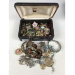 A vintage jewellery box containing a large quantity of vintage costume jewellery, including paste