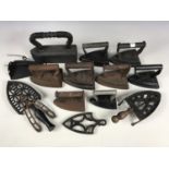 A quantity of cast iron sad irons together with a tailor's iron and trivets etc