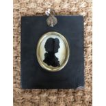 A Georgian silhouette portrait of a lady reverse painted on glass with lace bonnet and ruffle