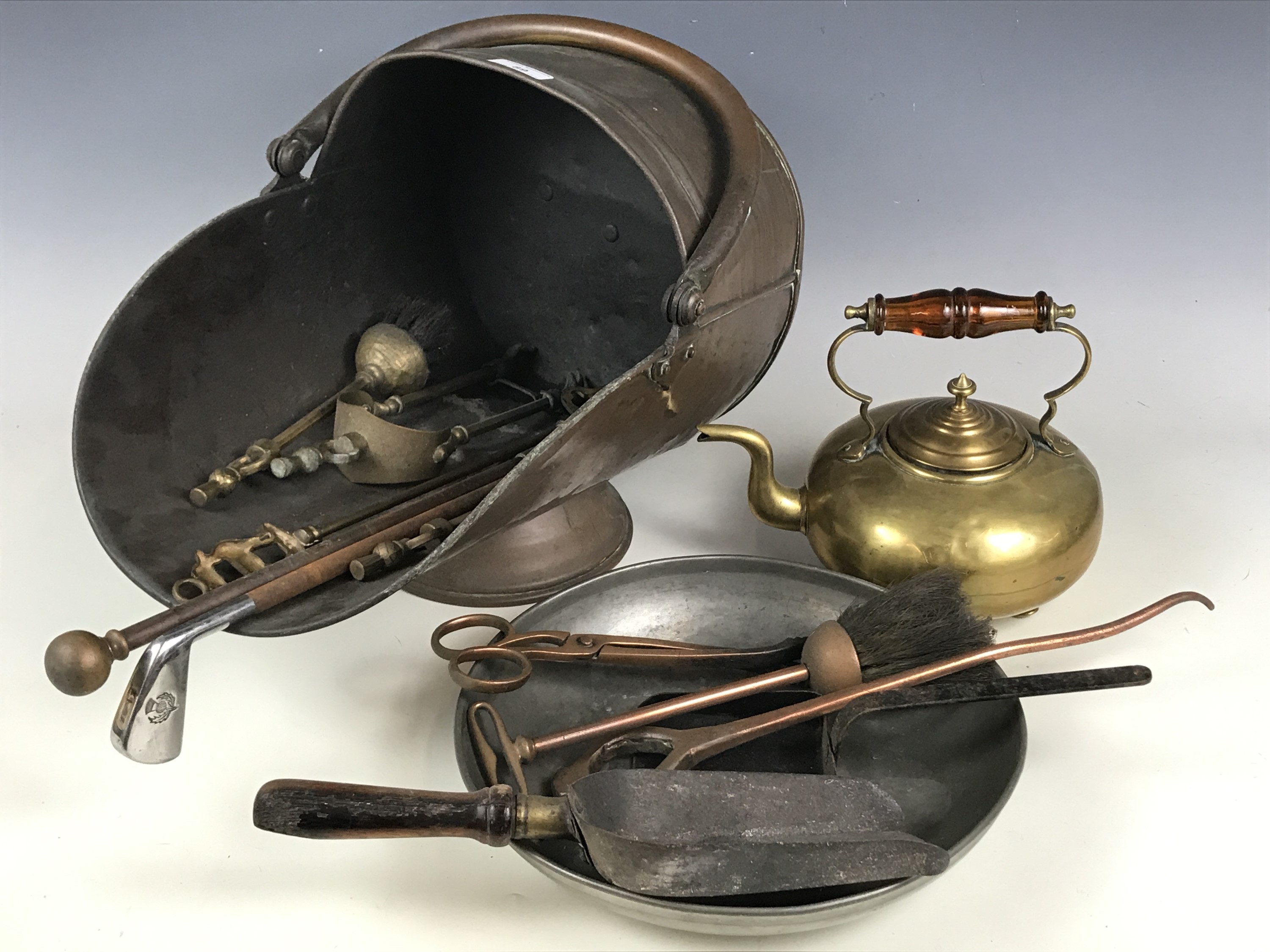 A Victorian copper coal helmet together with a brass kettle, Scottish thistle pattern hearth