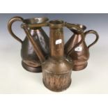 Two copper measuring jugs, one and two gallons respectively, together with a copper watering can