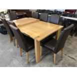 A contemporary light oak extending dining table and eight chairs