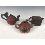Three Chinese Yixing teapots, one having a dragon handle and phoenix spout, impressed character