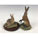 A Border Fine Arts figurine depicting a rabbit together with one other depicting a hare (a/f)