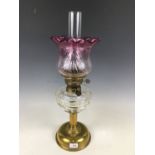 A Victorian brass columnar oil lamp with cut glass reservoir and achromatizing glass globe