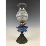 A Victorian oil lamp having a hand-enamelled blue glass reservoir and cut-glass shade, 40 cm