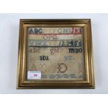 A Victorian needlework alphabet sampler, worked in wool threads over aida, framed under glass, 16.