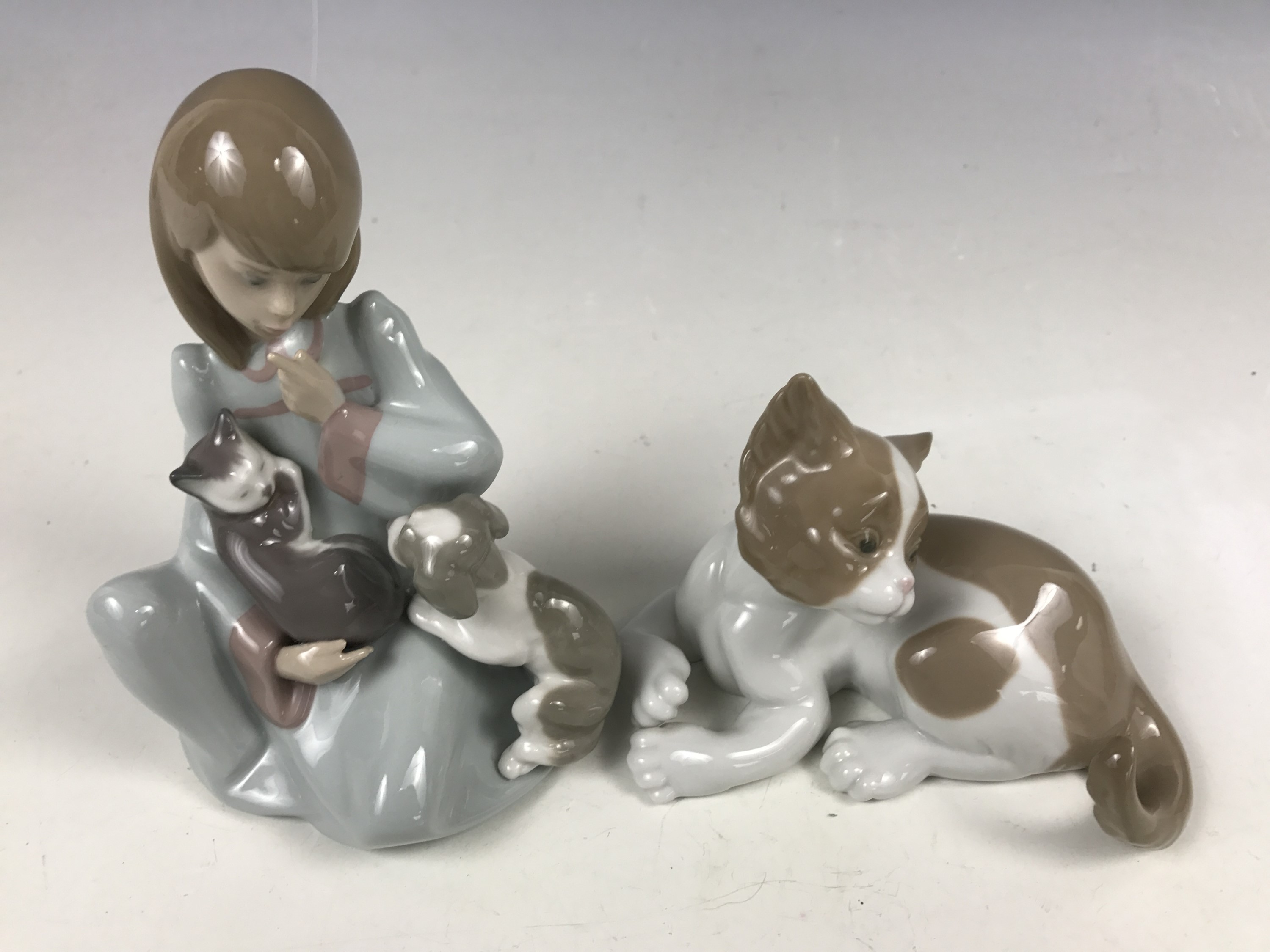 A Lladro figurine modelled as a girl with a kitten and puppy, 5640, together with one other Lladro