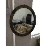 An early 20th Century brass framed circular wall mirror, having applied bosses to the four