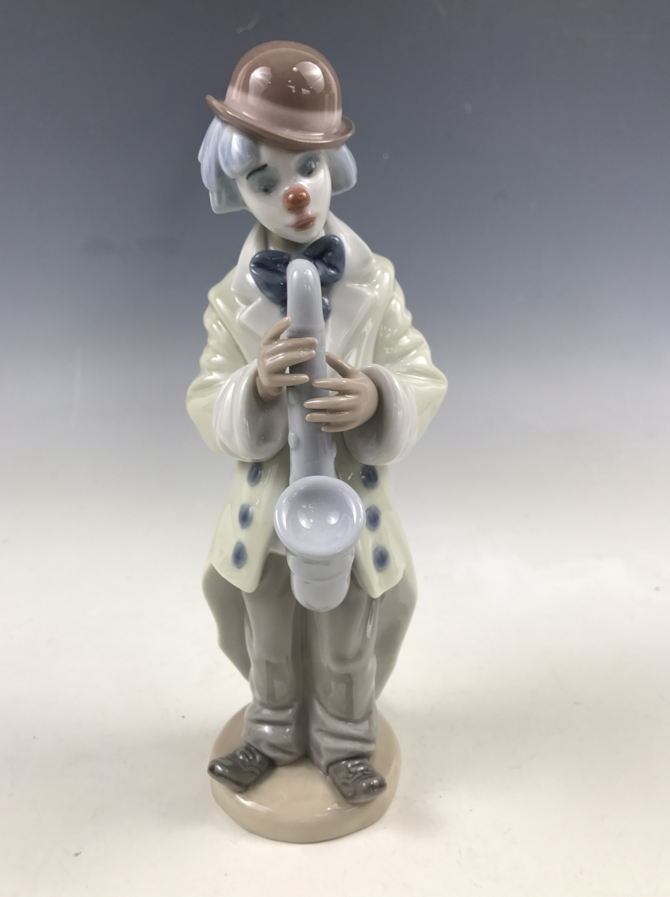 A Lladro figurine modelled as a clown with a saxophone, model 3471, 23 cm