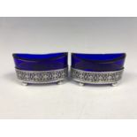 A pair of electroplate mounted table salts, of navette form with cobalt blue glass liners