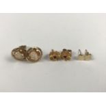 Two pairs of 9ct gold stud earrings, one pair modelled as flower-heads with central claw-set