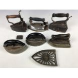 Six late 19th / early 20th Century sad irons and a trivet